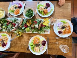 Table dressée avec des assiettes de crudités (carottes, betteraves, salades, radis) pour la remontée alimentaire après un jeûne hydrique 